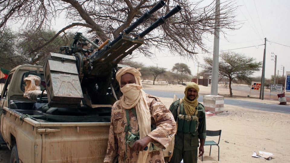 Zwei Touareg-Kämpfer vor einem Pick-Up-Wagen mit Artillerie-Geschütz