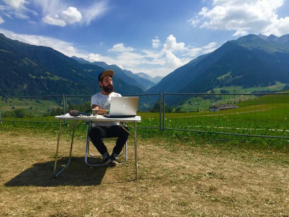 Moderator Andi Rohrer mit Laptop und Tisch in einer wunderbaren Landschaft