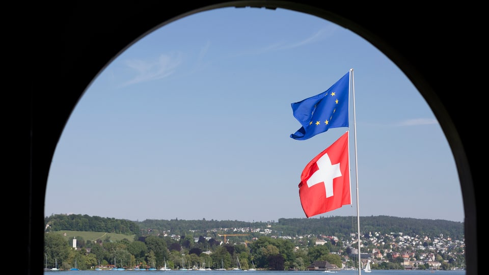 Eine Schweizer und eine EU-Flagge wehen in Zürich. 