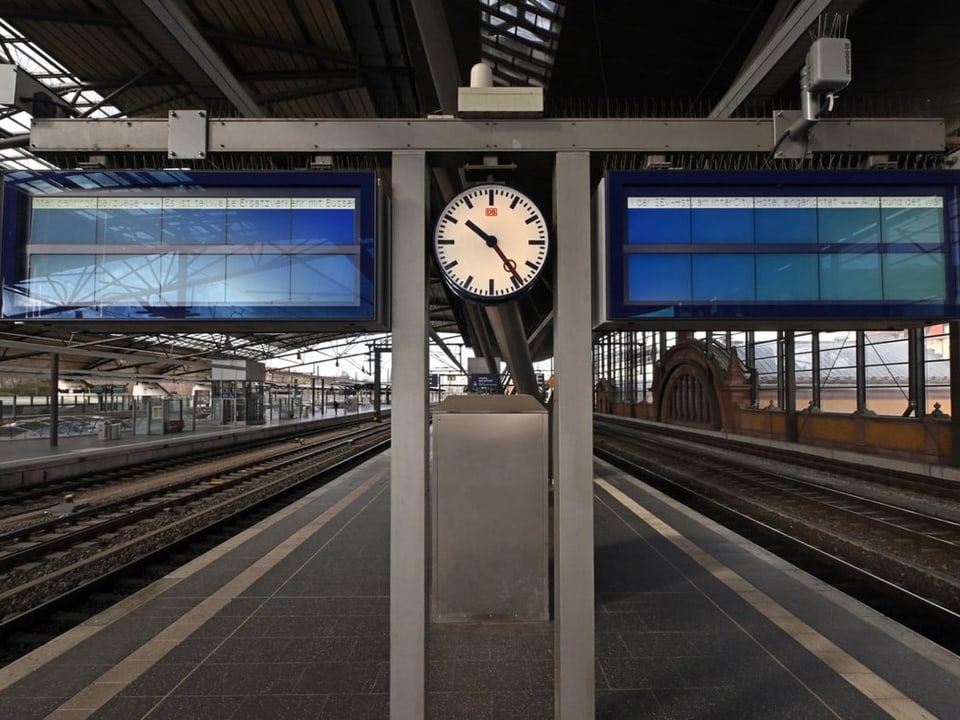 Ein Bahnhof ohne Züge und Menschen sowie zwei leere Bildschirme 