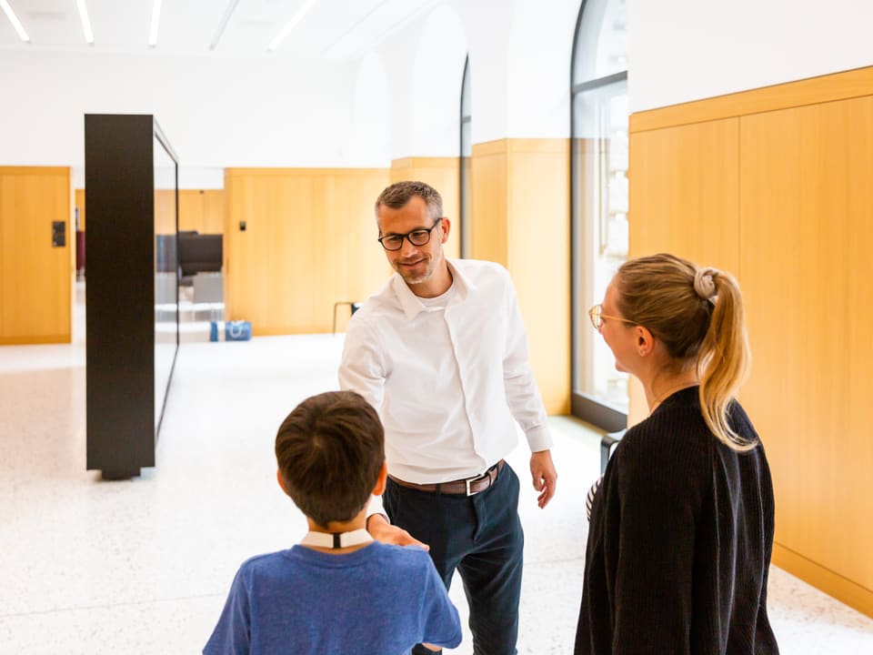 Silvio Schumacher begrüsst Anna Zöllig und SRF Kids Reporter Simon (11) im Forum der Schweizer Nationalbank in Zürich.