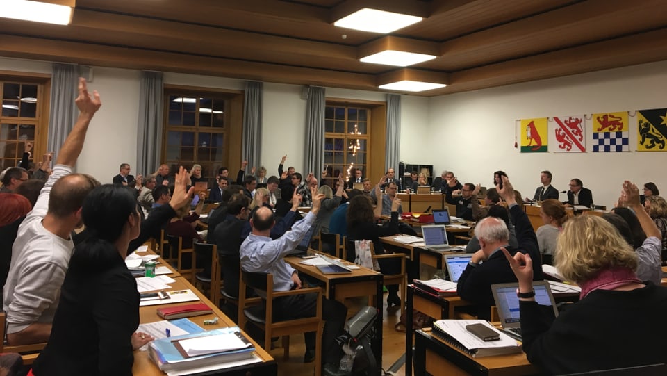 Gemeinderäte stimmen per Handzeichen ab im Parlament. 
