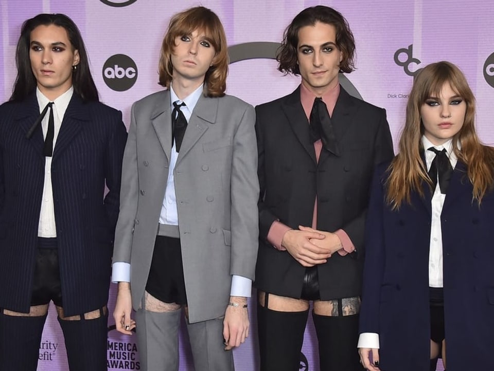 Måneskin posieren, in Anzügen von Gucci, an den American Music Awards vor der Fotowand.