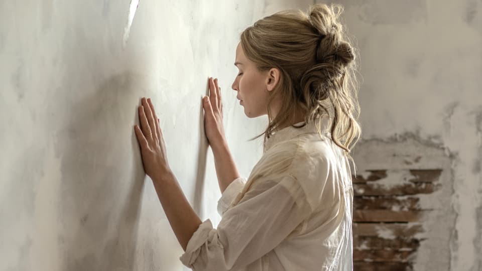 Frau mit geschlossenen Augen hält Hände gegen eine Wand