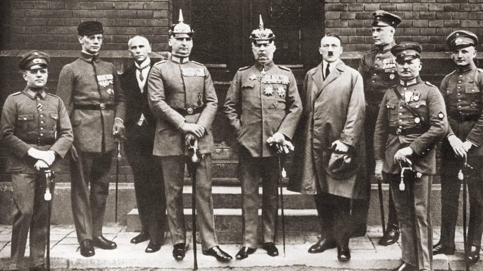 schwarz-weiss Foto neuen Männer in militärisch aussehender Kleidung, stehend mit Stock. 