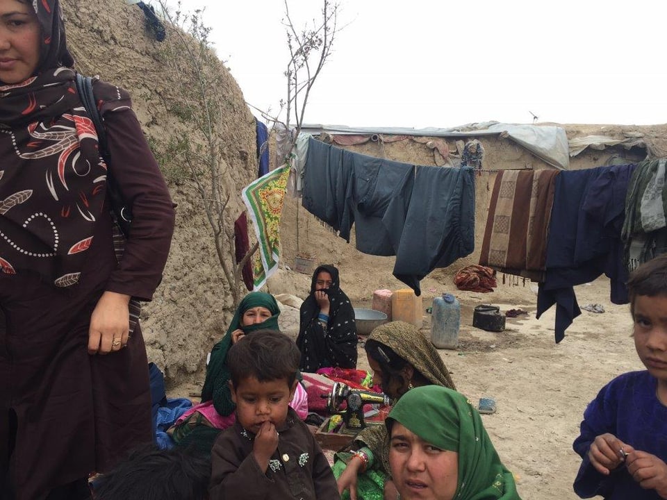 Frauen und Kinder vor einer Wäscheleine im Flüchtlingscamp.