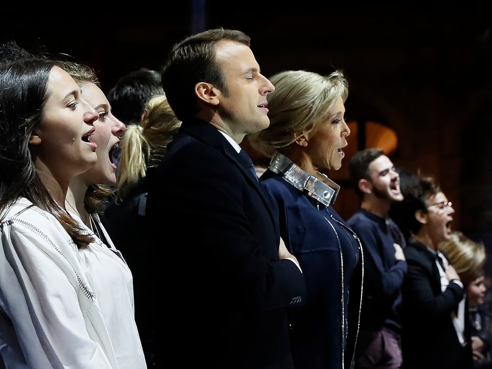 Emmanuel Macron und Brigitte Macron singend.