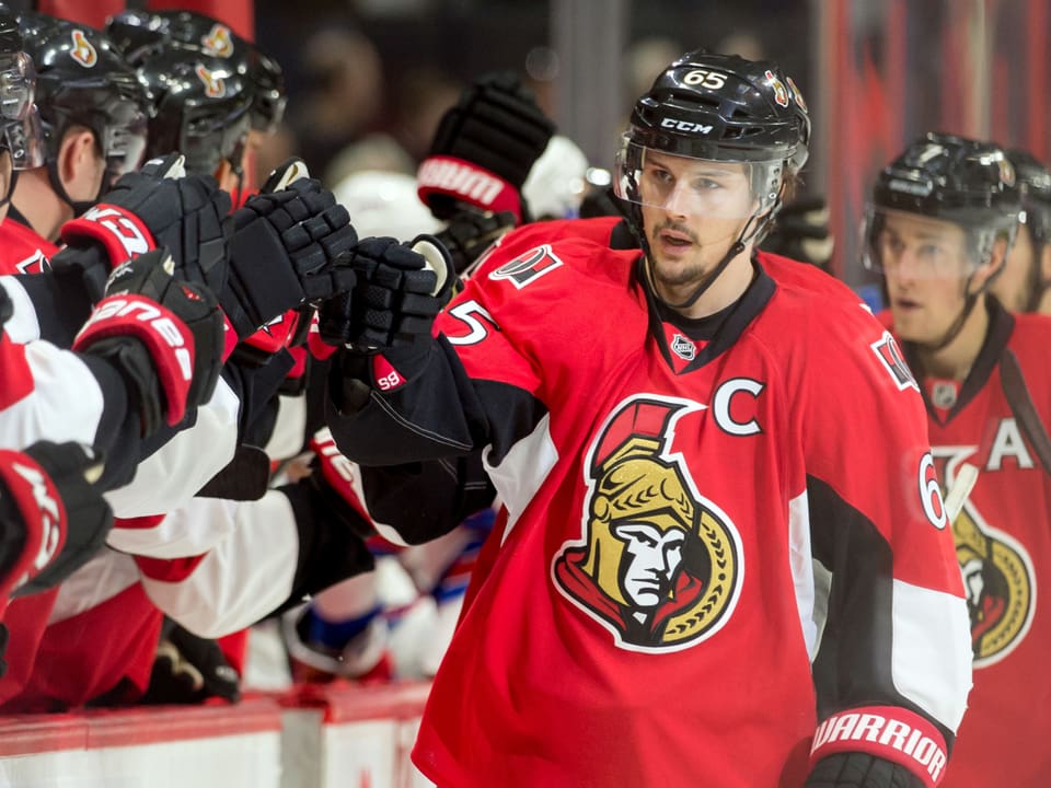 Karlsson im Ottawa Dress klatscht mit den Spieler bei der Bank ab.