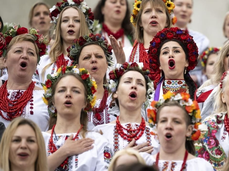 Chor von Frauen in traditionellen ukrainischen Trachten singt.