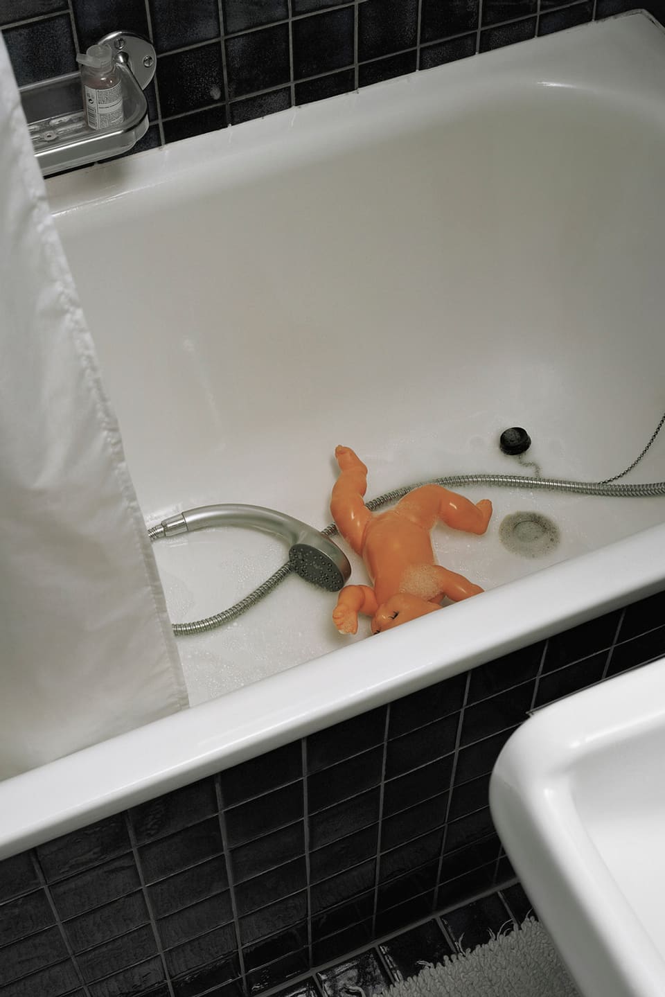 Eine Puppe in einer Badewanne.