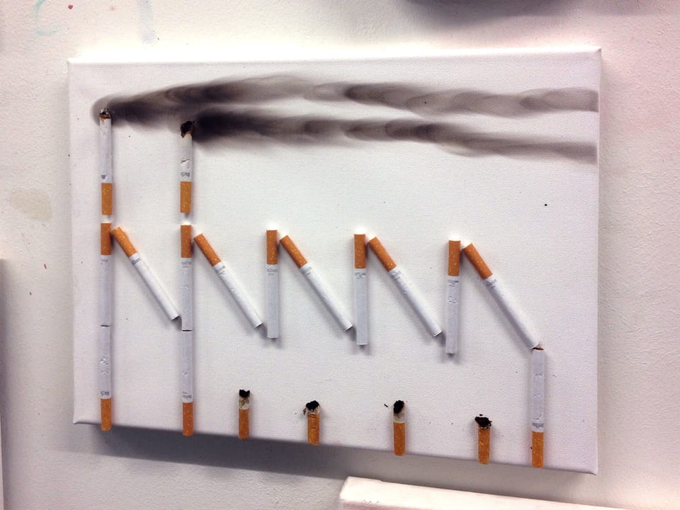 Ein Bild zeigt eine Fabrik, die mit Hilfe von Zigaretten dargestellt ist. 