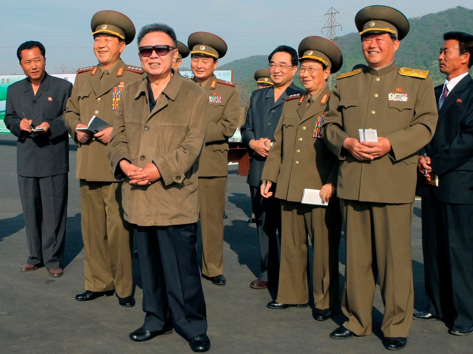 Kim Jong Il (mit Brille) neben Soldaten.