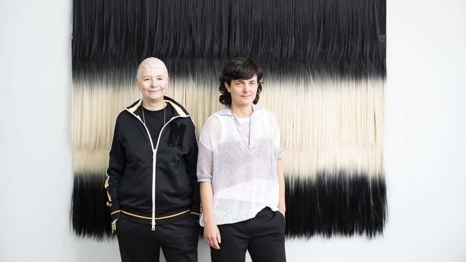 Porträt von Pauline Boudry und Renate Lorenz vor gestreift schwarz-weissem Aushang