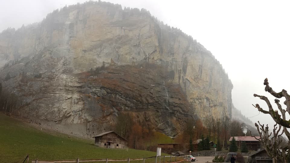 Felswand mit Bauernhäusern im Vordergrund