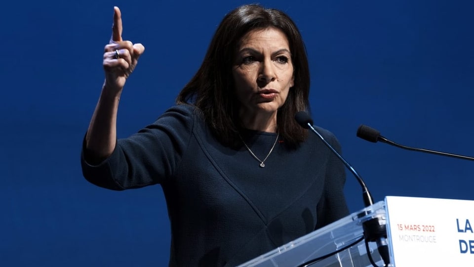 Anne Hidalgo an einem Rednerpult, den Finger erhoben.