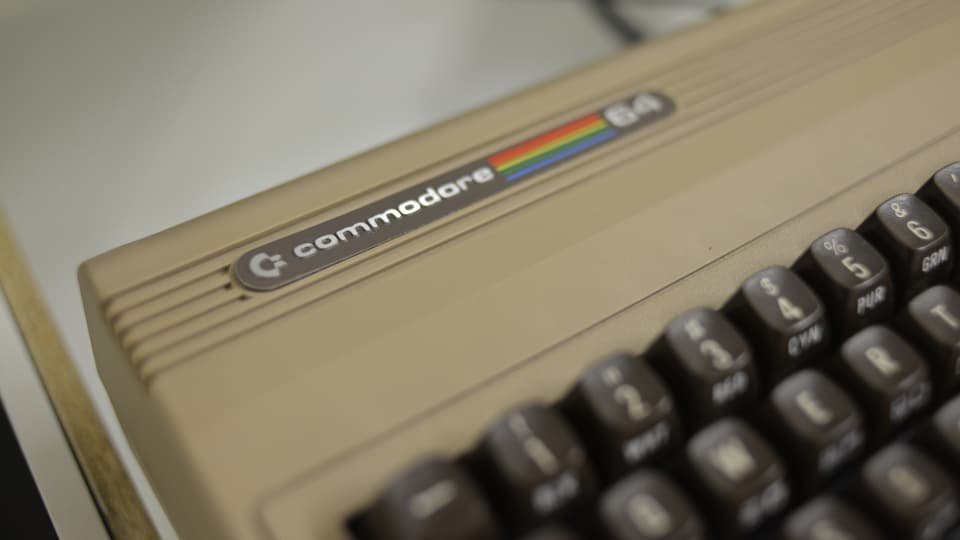 Die Logo-Plakette eine Commodore 64 links oben am Gehäuse der Tastatur.