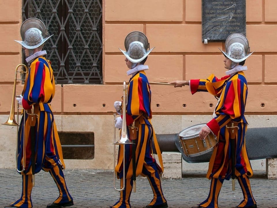 Schweizergardisten in traditioneller Uniform beim Marschieren in Rom.