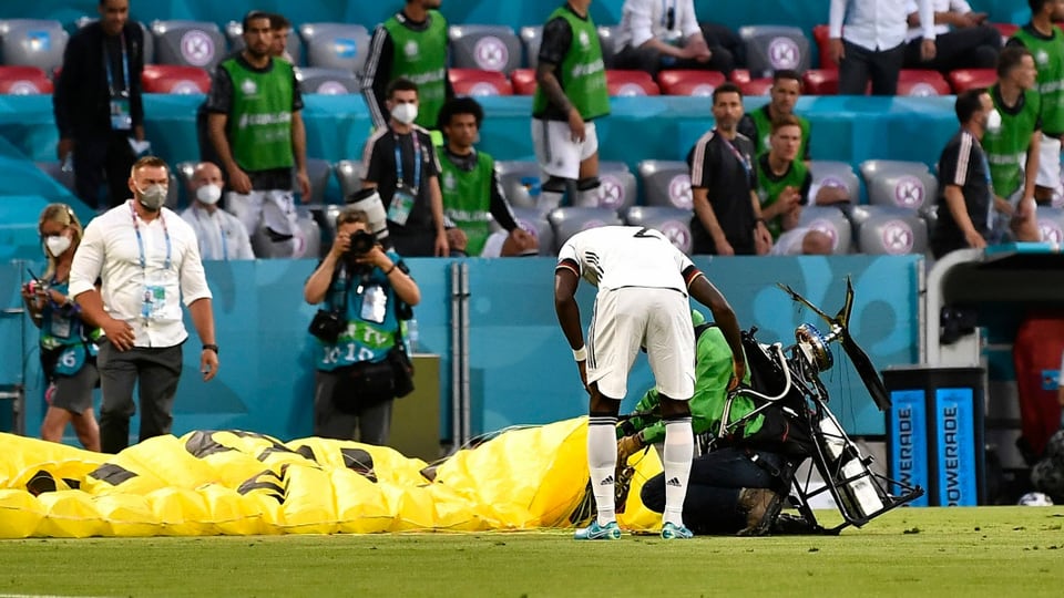Der Greenpeace-Aktivist war nach seinem missglückten Flug selber bei der Landung gestrauchelt. Der deutsche Spieler Antonio Rüdiger stand ihm am nächsten und eilte zu ihm. 