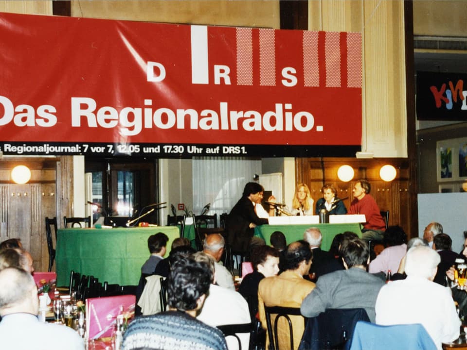Improvisiertes Radiostudio mit Gesprächsrunde in einer Messehalle.