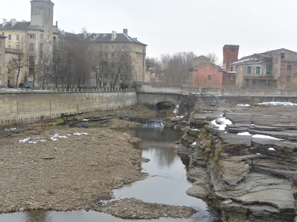 Die Narva, dahinter eine Steinbrücke und einige Häuser