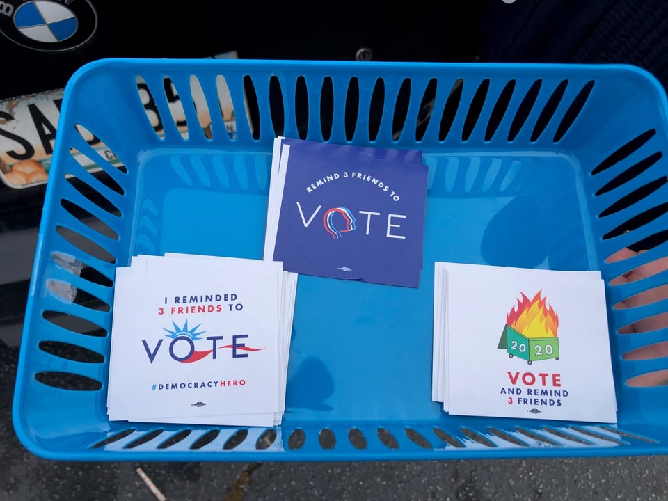 Ein blauer Plastikkorb mit Klebern demokratischer Wahl-Aktivisten.