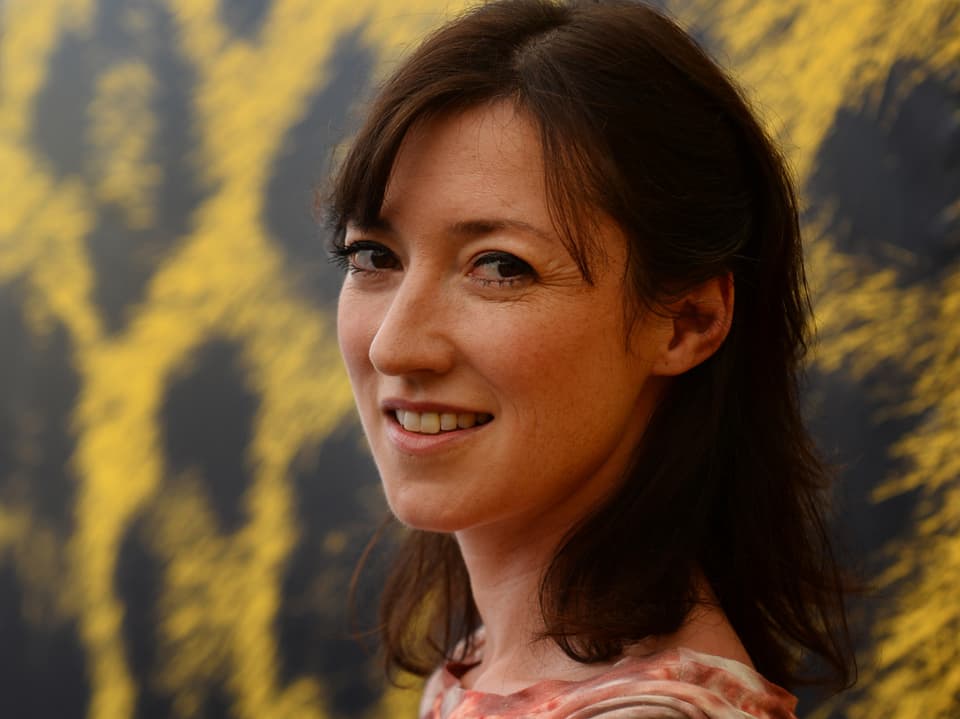 Charlotte Roach vor dem schwarz-gelben Poster des Filmfestivals Locarno