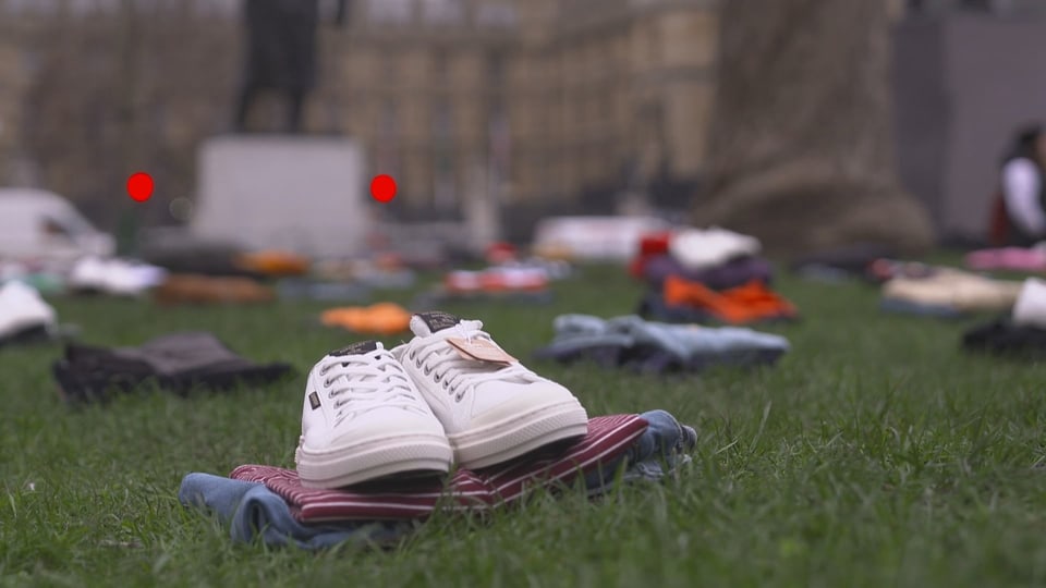 Auf der Wiese vor dem britischen Parlament in London liegt stellvertretend für jedes Todesopfer ein Bündel Kleider.