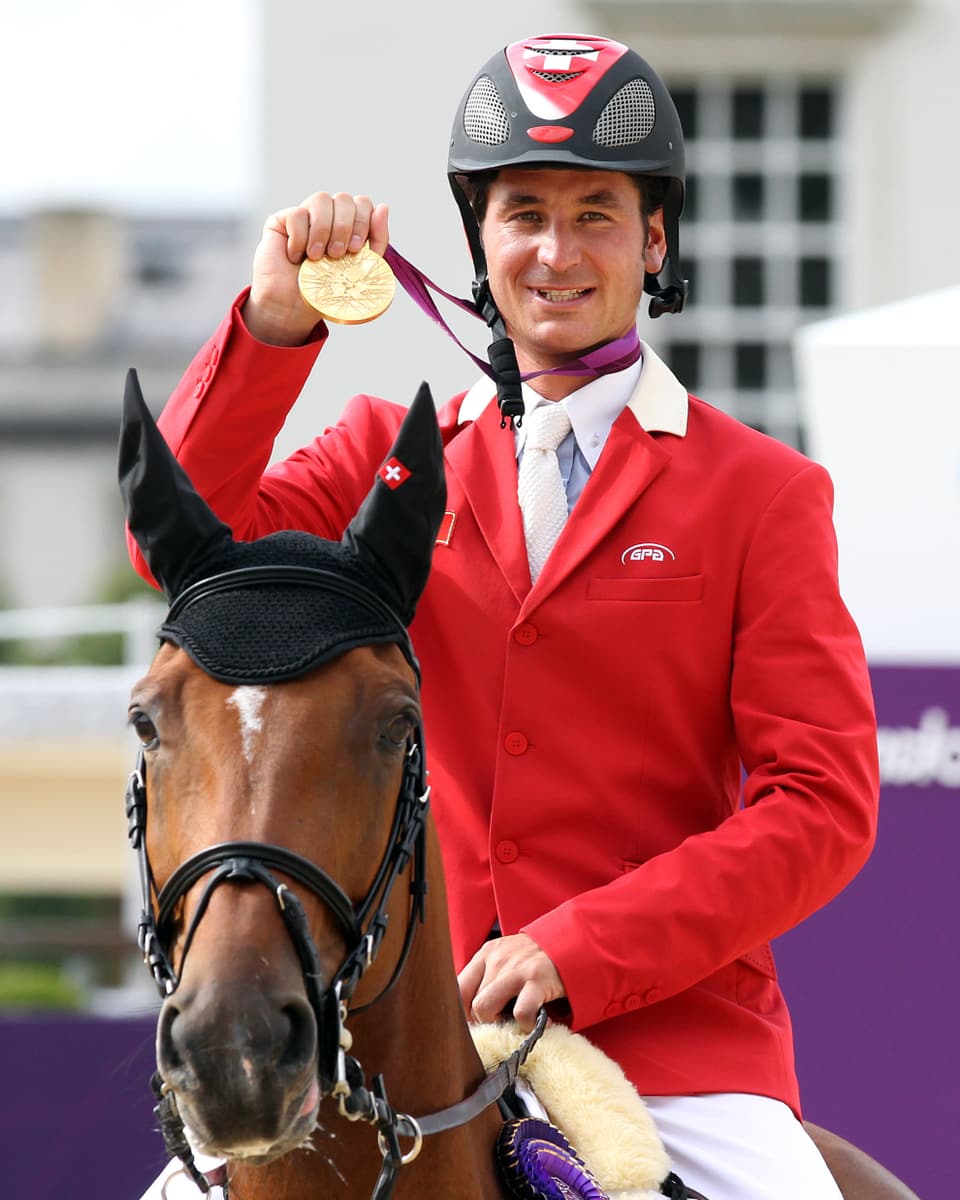 Steve Guerdat posiert auf Nino des Buissonnets mit Olympia-Gold.
