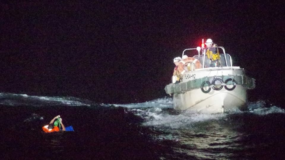 Ein Crewmitglied des gesunkenen Frachtschiffs wird von der Küstenwache gerettet.