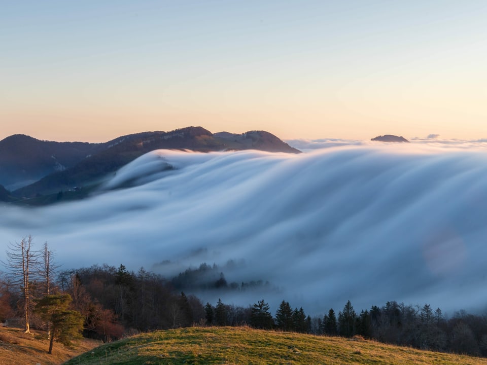 Nebelfall wie Wasser von einem Hügel herunter