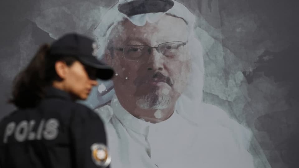 Eine türkische Polizistin vor einem Wandbild des ermordeten Journalisten am ersten Jahrestag seiner Ermordung 2019.