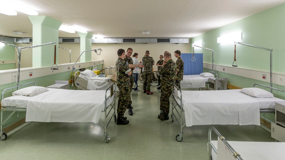Soldaten zwischen Spitalbetten.