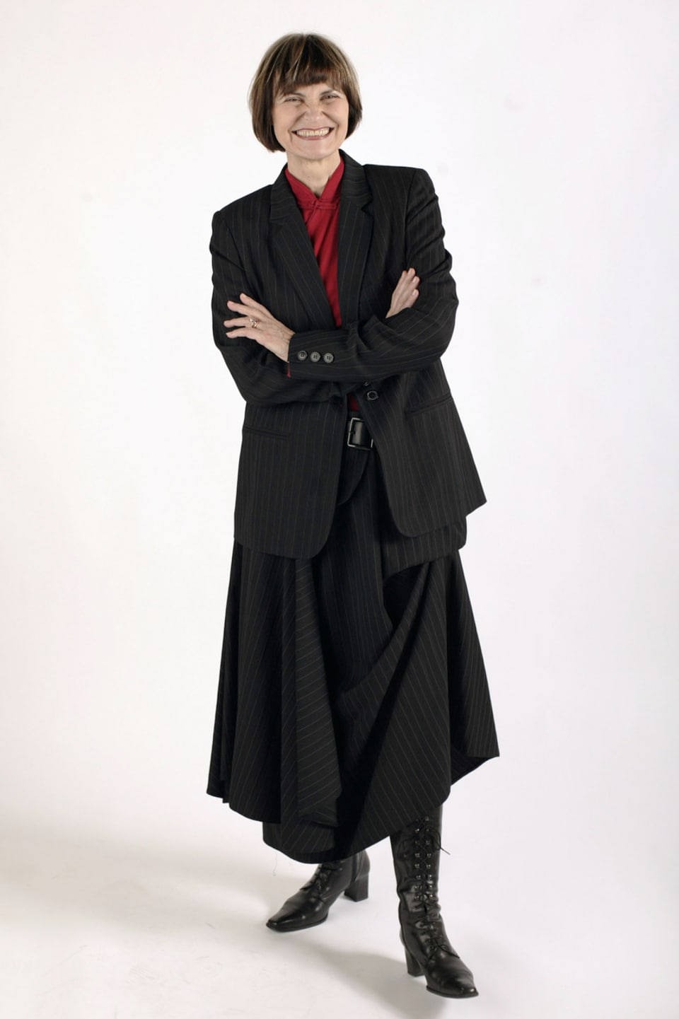 Micheline Calmy-Rey im schwarzen langen Jupe, dunklen Stiefeln, roter Bluse und schwarzem Sakko.