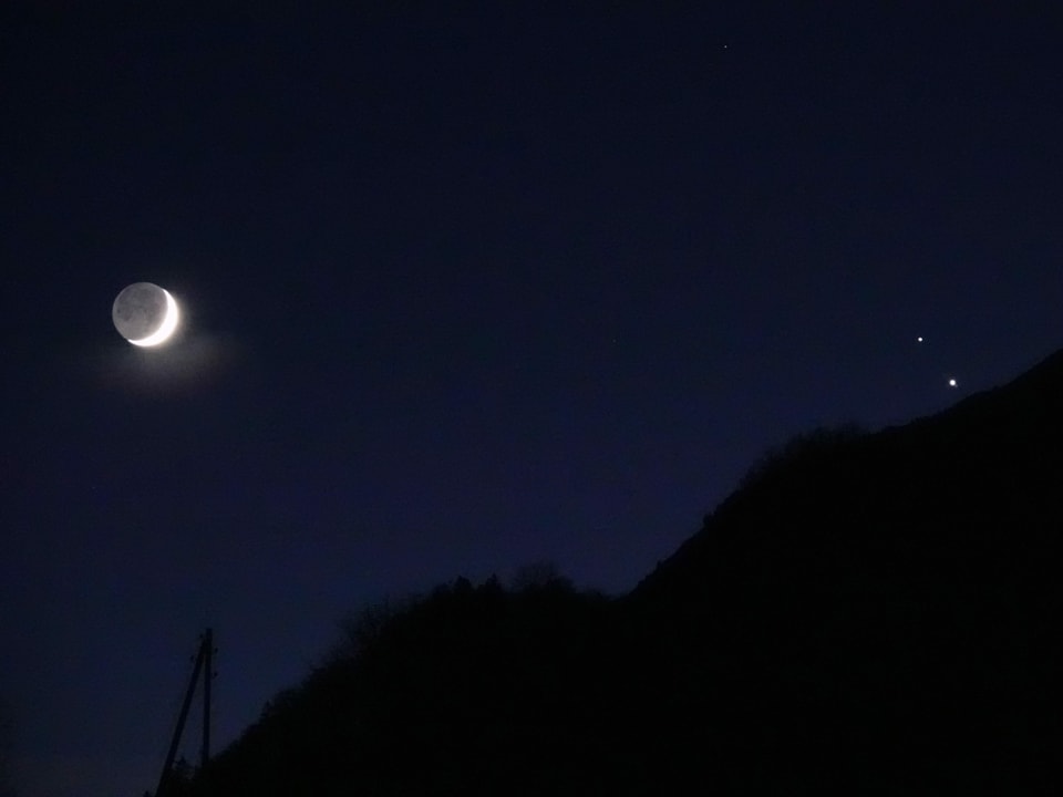 Mond, Saturn und Jupiter am Nachthimmel.