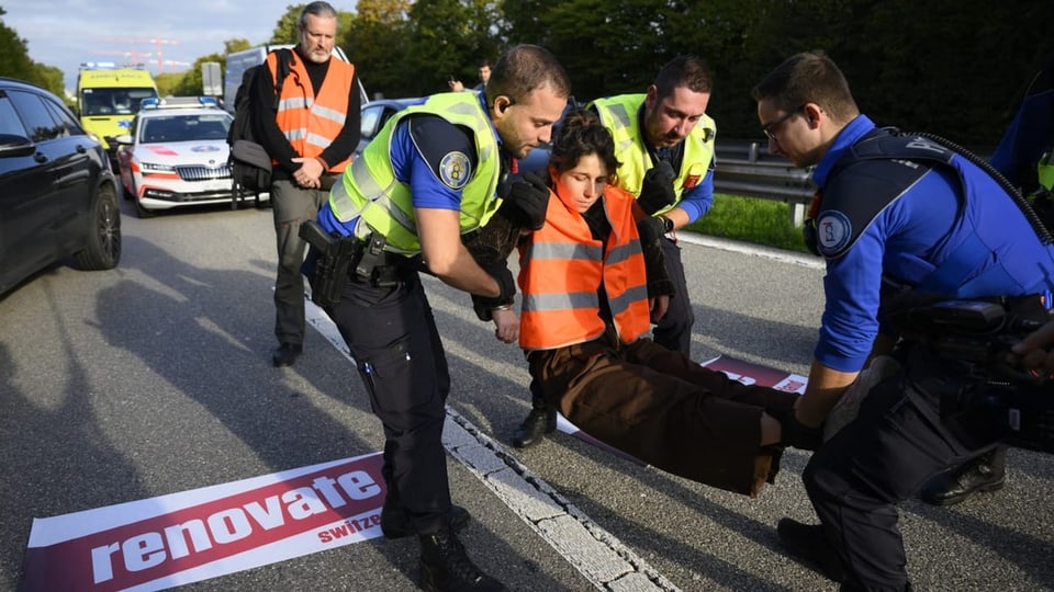 Polizeibeamte nehmen einen Umweltaktivisten von Renovate Schweiz fest.