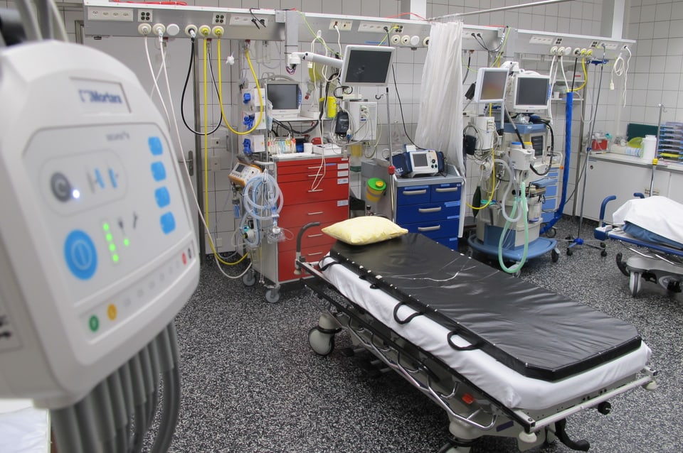 Raum mit zwei Betten und diversen medizinischen Geräten.