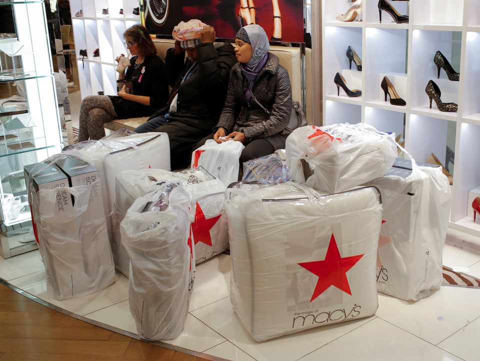 Kunden von Macy's gönnen sich umringt von den Shopping-Tragtaschen eine Pause. 