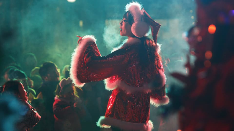 Eine Chinesin im Weihnachtskostüm auf der Bühne.