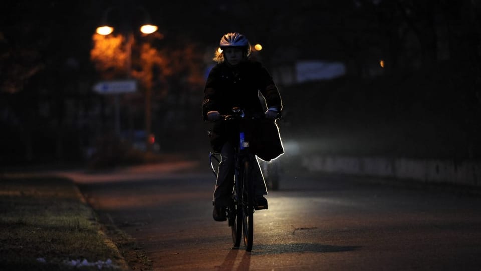 Fahrradfahrerin fährt ohne Licht auf der Strasse