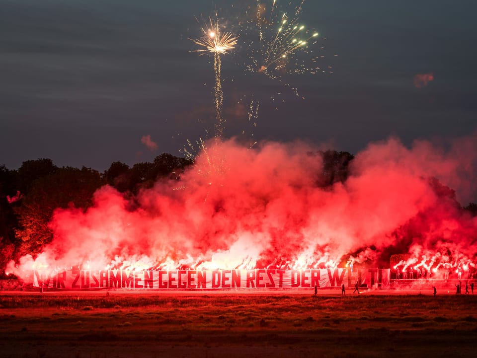 Dresden-Fans mit Spruchband "Wir zusammen gegen den Rest der Welt" und Pyros
