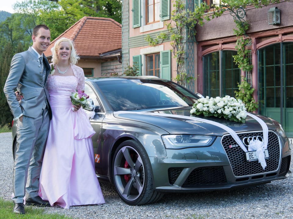 Hochzeitspaar vor geschmücktem Audi