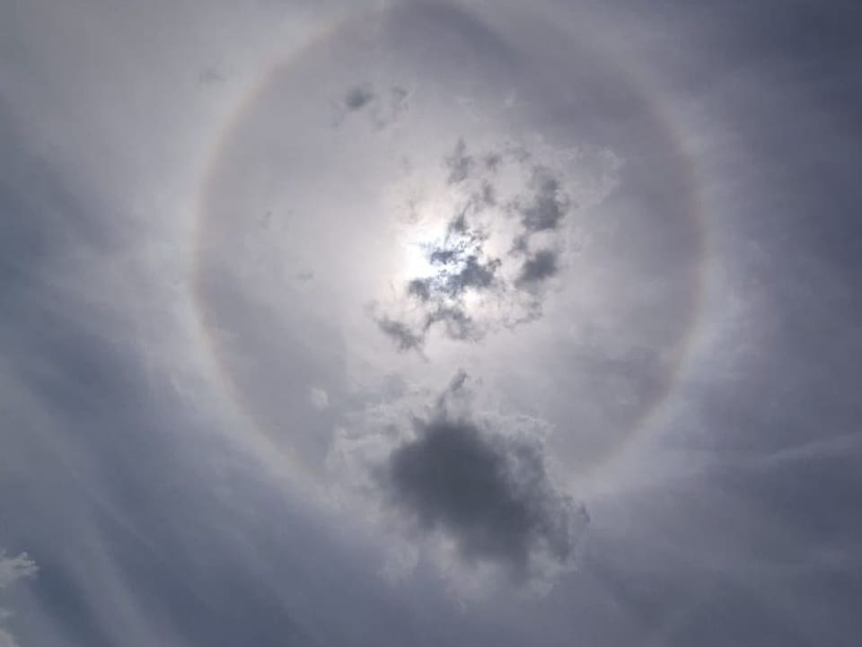 Regenbogen-Ring um die Sonne am milchigen Himmel