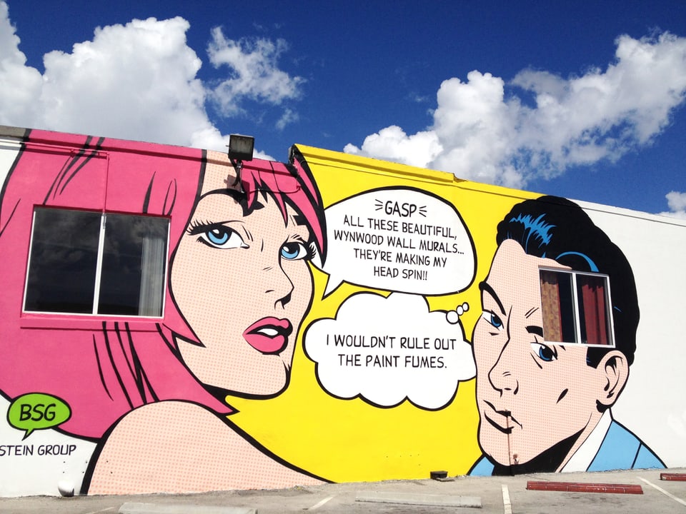 Auf eine Mauer sind im Comic-Stil eine Frau und ein Mann mit Sprechblasen gemalt.