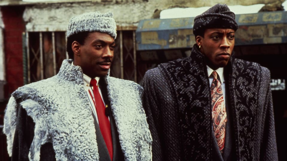 Film-Still aus Coming to America: Eddie Murphy und Arsenio Hall stehen nebeneinander auf der Strasse.