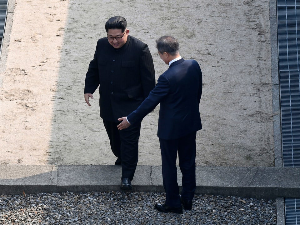 Nordkoreas Präsident Kim Jong-un (l.) betritt südkoreanischen Boden, Südkoreas Präsident Moon Jae-in