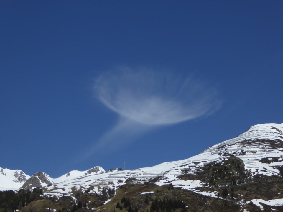 Feine haarähnliche Wolke in Quellen oder Trochterform am blauen Himmel. 