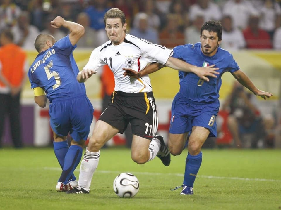 Miroslav Klose im Duell gegen zwei italienische Gegenspieler