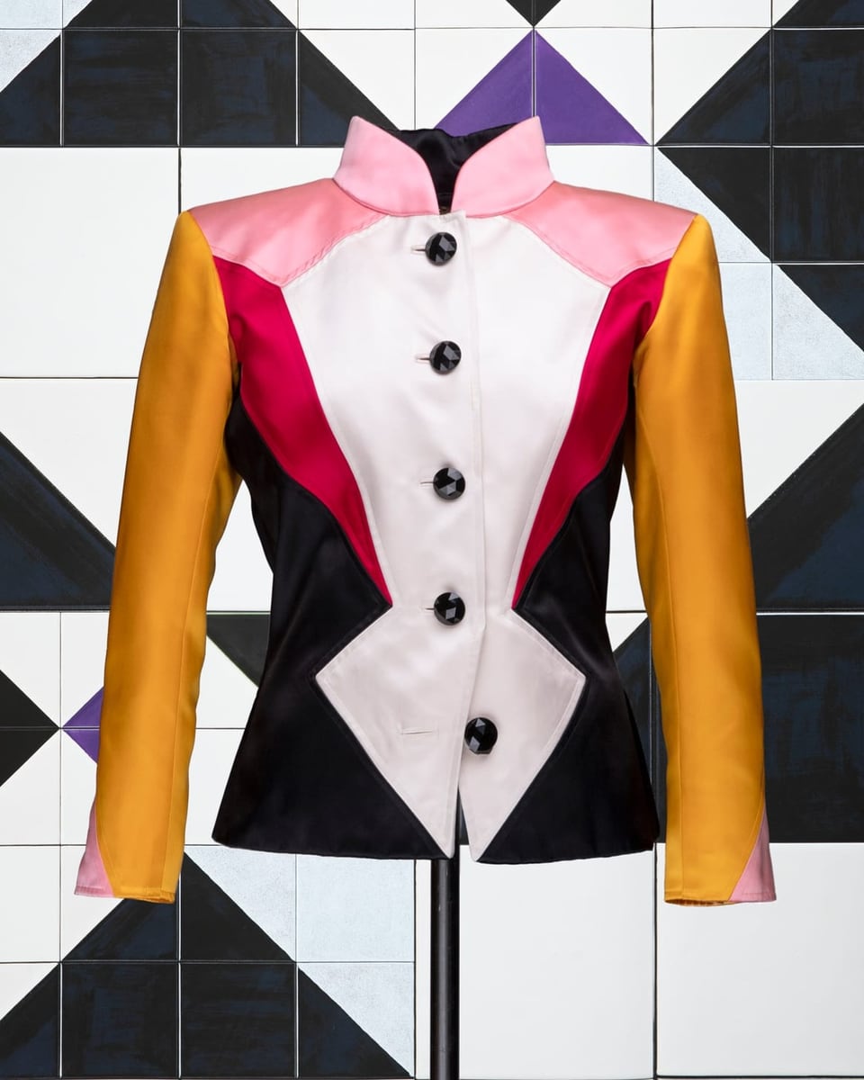Jacket in large, white jagged front, red stripes on the right and left, mustard yellow sleeves, pink shoulders.