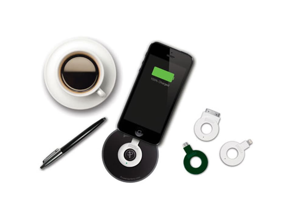 Kaffeetasse, Handy mit angeschlossenem Ring-Adapter, daneben ringförmige Adapter.