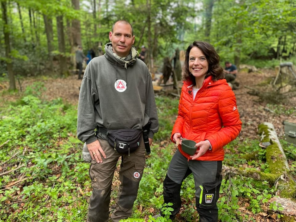 Ein Mann und eine Frau stehen nebeneinander im Wald.